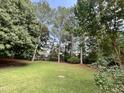 Expansive backyard with lush green grass and mature trees creating a private outdoor oasis at 3212 Potthast Ct, Raleigh, NC 27529