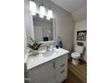 Bright bathroom featuring modern fixtures, stylish vanity, with a quartz countertop, and woodgrain floors at 3212 Potthast Ct, Raleigh, NC 27529