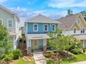 Charming two-story blue home with a yellow door, front porch, and landscaped front yard at 322 Tobacco Farm Way, Chapel Hill, NC 27516