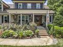 Inviting front porch with stone accents, classic columns, and an American flag waving in the breeze at 3581 Boulder Ct, Wake Forest, NC 27587