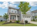 Inviting two-story home with a two-car garage, gray siding, and a well-landscaped lawn at 478 Curling Creek Dr, Clayton, NC 27527