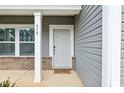 Close-up of the front door featuring brick accents and a 'Welcome Friends' doormat at 478 Curling Creek Dr, Clayton, NC 27527