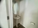 Cozy powder room with a stylish pedestal sink, oval mirror, and modern fixtures at 50 Teal Dr, Youngsville, NC 27596