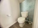 A clean, modern toilet with unique blue patterned wallpaper accents at 50 Teal Dr, Youngsville, NC 27596