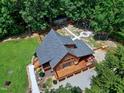 Overhead perspective of a well-maintained log home showcasing its large deck and wooded lot at 52 Buoy Dr, Henderson, NC 27537