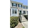 Charming townhouse exterior featuring green shutters, a well-manicured lawn, and concrete stairs to the front door at 5419 Vista View Ct, Raleigh, NC 27612