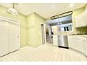Well-lit kitchen featuring white cabinets, white flooring and stainless steel appliances at 5419 Vista View Ct, Raleigh, NC 27612