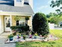 Inviting front yard with vibrant flower accents, lush landscaping, and a decorative front porch at 5849 Ricker Rd, Raleigh, NC 27610