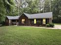 Brick home with large front lawn and a well-manicured landscape and mature trees around the property at 7194 Johns Point Ct, Liberty, NC 27298