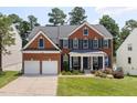 Beautiful two-story brick home with a manicured lawn, two-car garage, and a welcoming front porch at 8106 Sommerwell St, Raleigh, NC 27613