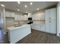 Bright kitchen features white cabinets, quartz countertops, stainless steel appliances, and a large island at 817 Kensley Grove Ln # 16, Fuquay Varina, NC 27526
