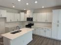Spacious kitchen features white cabinets, stainless steel appliances, and a kitchen island at 817 Kensley Grove Ln # 16, Fuquay Varina, NC 27526