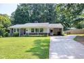 Charming single-story brick home featuring a well-manicured lawn and covered carport with long driveway at 827 Union St, Cary, NC 27511
