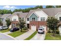 Inviting townhomes showcase a mix of brick and siding, complemented by mature trees at 927 Contessa Dr, Cary, NC 27513
