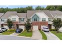 Attractive townhome with brick accents, individual driveways, and lush green lawns at 927 Contessa Dr, Cary, NC 27513