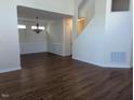 Open-concept living room with hardwood floors, chandelier, and wainscoting at 108 Bally Shannon Way, Apex, NC 27539