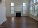 Spacious living room showcasing a fireplace and large windows for plenty of natural light at 108 Bally Shannon Way, Apex, NC 27539
