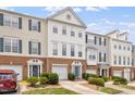 Street view of townhomes boasting brick facades and colorful exteriors on a partly cloudy day at 110 Great Ridge Ct, Morrisville, NC 27560