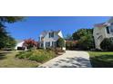 A nicely landscaped driveway leads to a charming home with green shutters at 1106 Brittley Way, Apex, NC 27502