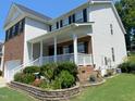 Charming two-story home featuring a welcoming covered porch and beautifully landscaped flower beds at 1126 Woodlands Creek Way, Apex, NC 27502