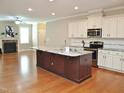 Open kitchen with stainless steel appliances, an island and sight lines to the living room at 120 Glen Oaks Dr, Youngsville, NC 27596