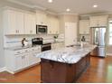 Bright kitchen featuring an island, granite countertops, stainless steel appliances, and ample storage at 120 Glen Oaks Dr, Youngsville, NC 27596