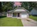 Charming single-story home with a manicured lawn, inviting front porch, and an attached single-car garage at 125 Brook Pl, Smithfield, NC 27577