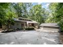 Charming gray home featuring a separate garage, clerestory windows, and wooded lot at 127 Creekwood, Pittsboro, NC 27312