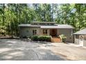 Gray home featuring a separate garage, clerestory windows, and wooded lot at 127 Creekwood, Pittsboro, NC 27312