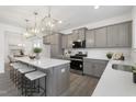 Open kitchen featuring a large island with seating, quartz countertops, and stainless steel appliances at 130 Summer Mist Ln # 160, Clayton, NC 27527