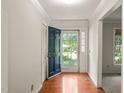 Bright foyer featuring hardwood floors, a coat closet, and a glimpse of the lush outdoors through the front door at 1317 Elmset Ln, Durham, NC 27713