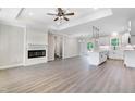Open-concept living space featuring hardwood floors, a fireplace, and a view of the modern kitchen at 157 Cherrybirch Ln, Zebulon, NC 27597