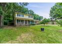 A yellow and brick two-story home with a covered front porch and a green lawn at 1704 Little John Ct, Burlington, NC 27217