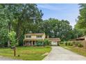 A two-story home with a yellow exterior, a brick accent, a covered front porch, and a long driveway at 1704 Little John Ct, Burlington, NC 27217