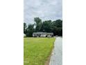Picturesque home with a sprawling front yard, gravel driveway, and mature trees at 175 Ann Dr, Timberlake, NC 27583