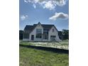 Exterior of new construction home with stone facade, gray trim, and ample windows under a partly cloudy sky at 200 Meadow Walk Dr, Fuquay Varina, NC 27526