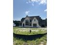 View of newly constructed home, featuring stone accents and a spacious three-car garage at 200 Meadow Walk Dr, Fuquay Varina, NC 27526
