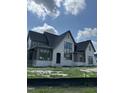 New home exterior showcasing stone details, gray trim, and an abundance of natural light through black windows at 200 Meadow Walk Dr, Fuquay Varina, NC 27526