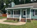 Charming porch with white railings and brick foundation, offering a perfect spot to enjoy the outdoors at 2012 Ranch Mill Cir, Raleigh, NC 27610