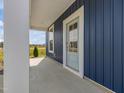 Covered front porch featuring blue vertical siding and a light blue front door at 227 Faith Avenue, Sanford, NC 27330