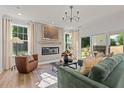 Bright living room with a fireplace, comfortable seating, and natural light streaming through large windows and sliding glass door at 235 Faith Avenue, Sanford, NC 27330