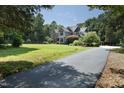 A long, paved driveway leads to a stately home surrounded by a lush, green lawn and mature trees at 267 Bald Eagle Dr, Pittsboro, NC 27312