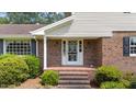 Classic brick front porch features white columns, a screen door, and traditional sconce lighting at 315 Crescent Dr, Clayton, NC 27520
