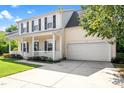 Traditional two-story home with a covered porch, attached garage, and lush green lawn at 3201 Sawyers Mill Dr, Apex, NC 27539