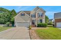 Traditional two-story home with manicured lawn, brick steps, neutral siding, and attached two car garage at 3212 Marblewood Ct, Raleigh, NC 27604