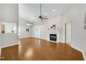 Spacious living room featuring hardwood floors, a ceiling fan, a fireplace, and a neutral color scheme throughout at 325 Millet Dr, Morrisville, NC 27560