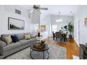 Inviting living room with a gray sofa, round coffee table, and a dining area with a table set for four at 325 Millet Dr, Morrisville, NC 27560