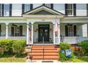 Charming front porch with patriotic decorations, brick steps, and welcoming entrance with black double doors at 401 N Main St, Louisburg, NC 27549