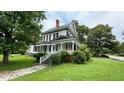 Inviting two-story home with a classic architectural design and covered side porch at 401 N Main St, Louisburg, NC 27549