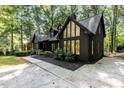 Striking exterior showcasing a home with dark siding, large windows, and a well-manicured lawn at 5217 West Oaks Dr, Fuquay Varina, NC 27526